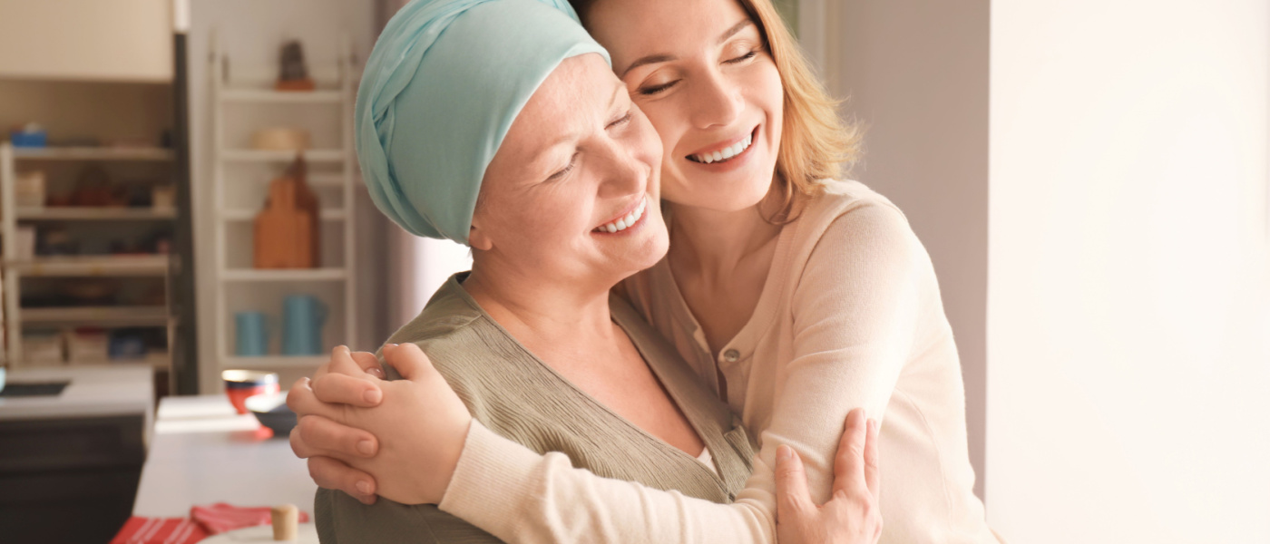 paziente con tumore abbraccia caregiver e sorridono