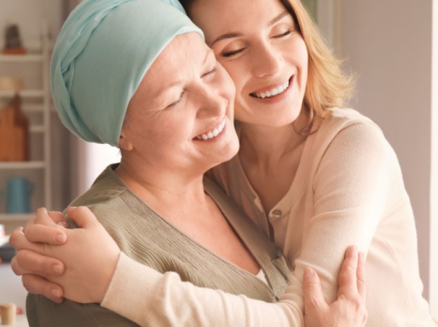 paziente con tumore abbraccia caregiver e sorridono