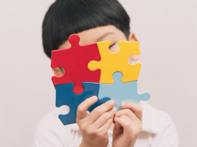 Bambino che tiene in mano un puzzle colorato