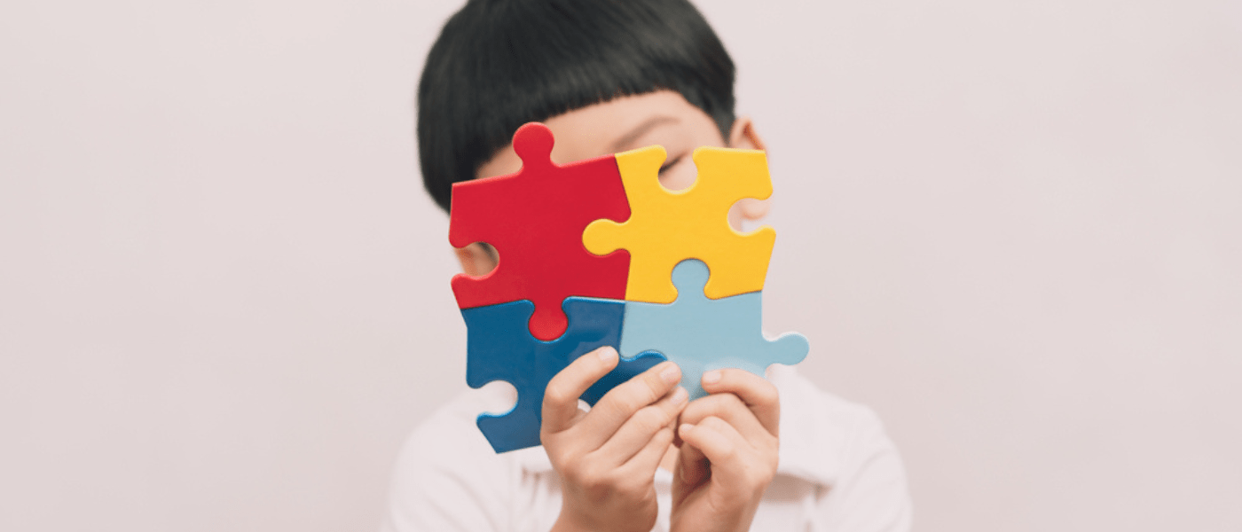 Bambino che tiene in mano un puzzle colorato