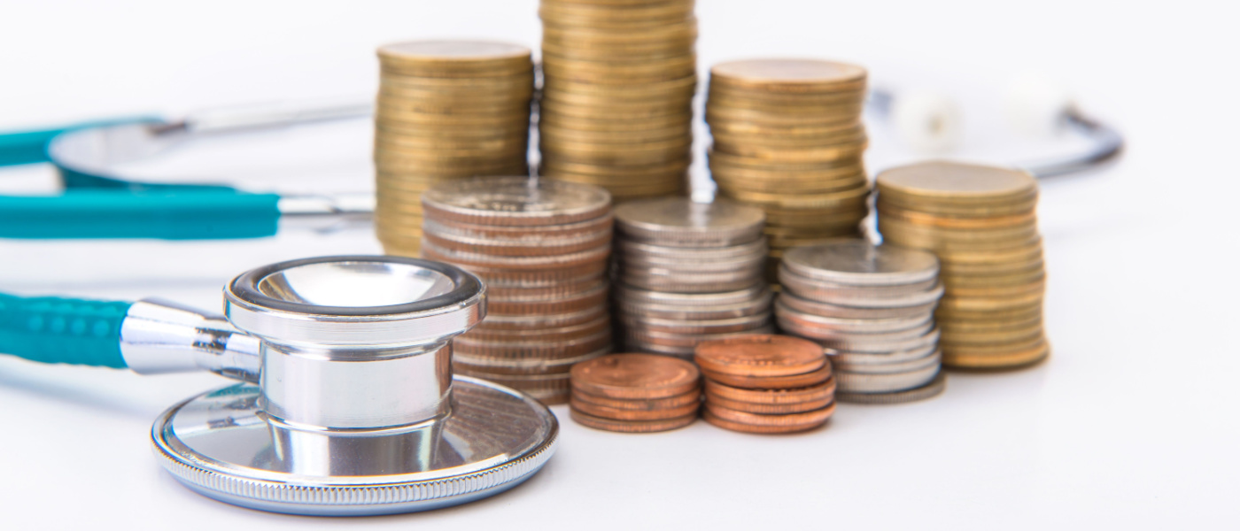 monete impilate a fianco ad uno stetoscopio