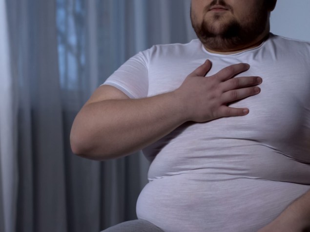 persona grassa con la mano sul petto