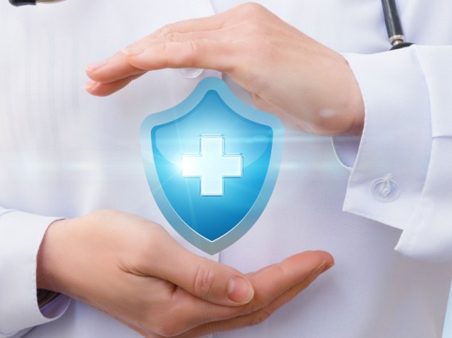 medico con tra le mani scudo digitale con croce medica