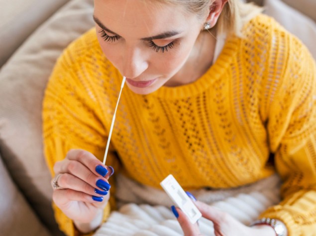 donna che effettua un tampone nasale fai da te a casa