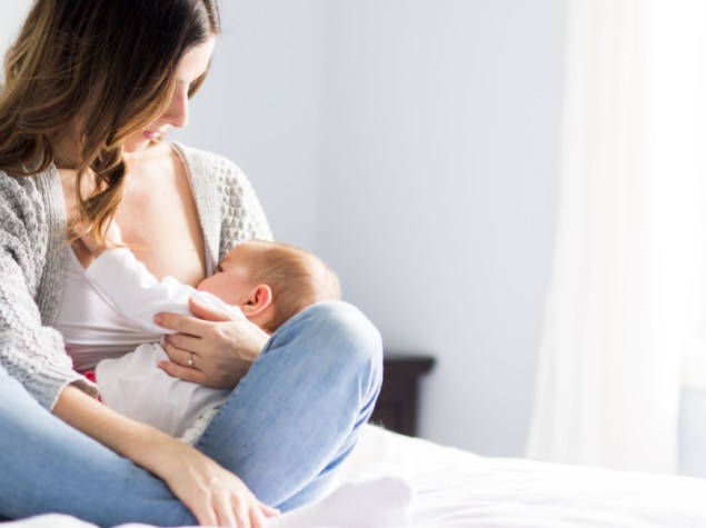 Donna allatta al seno bambino