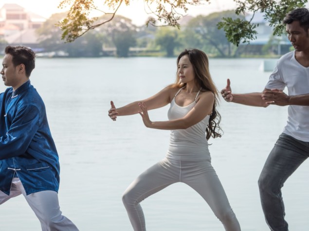 tre persone praticano lo Qigong