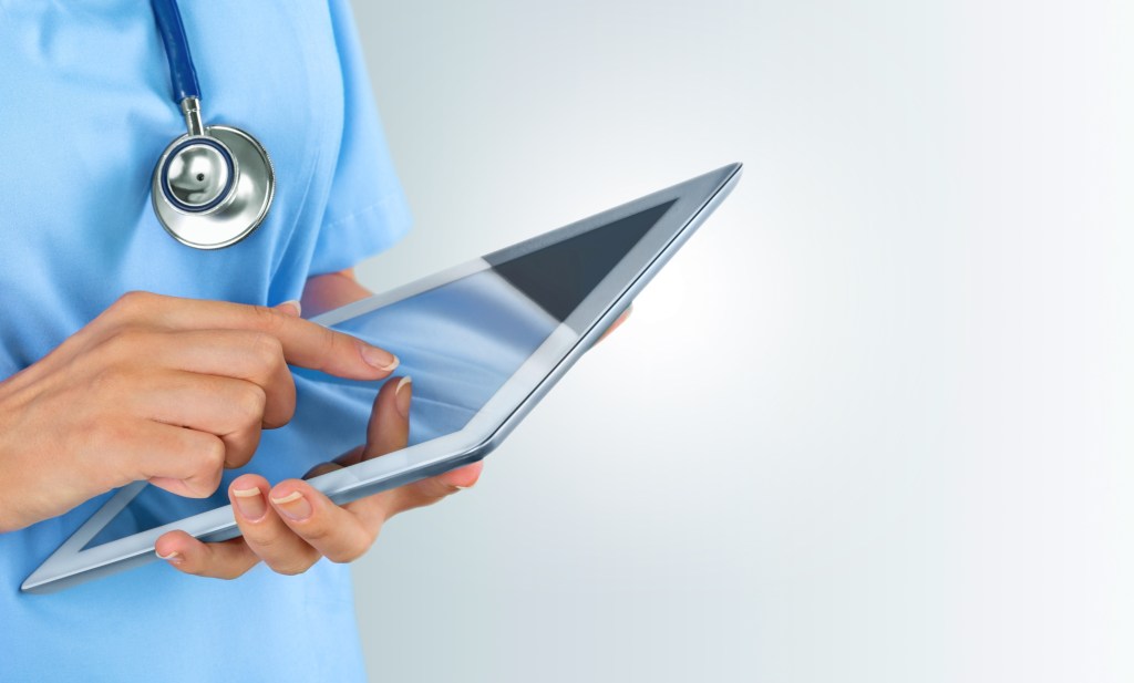 foto di un medico con camice che utilizza un iPad