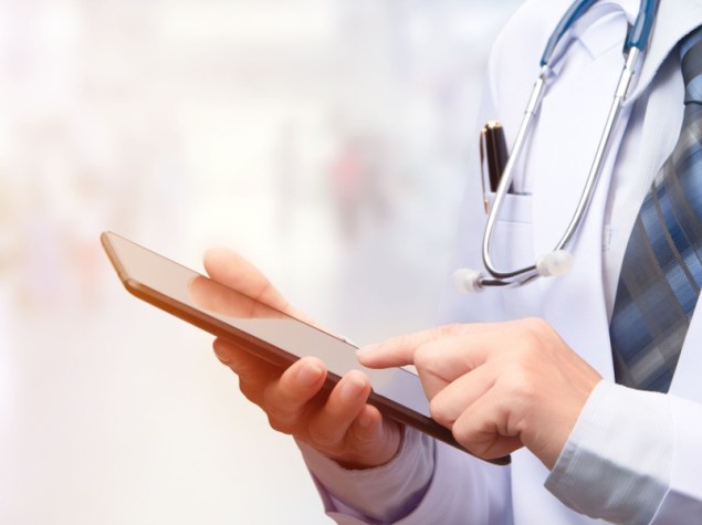 foto di un medico con camice che utilizza un iPad