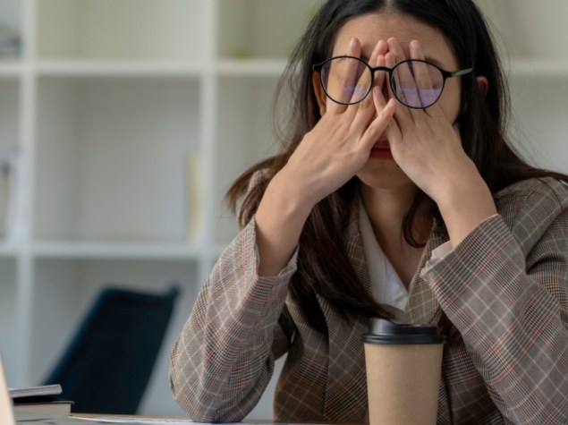 Donna con mani sul viso davanti al pc