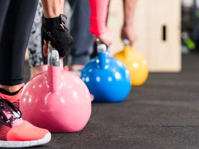 Gruppo con allenamento funzionale fitness con kettlebell in palestra sportiva