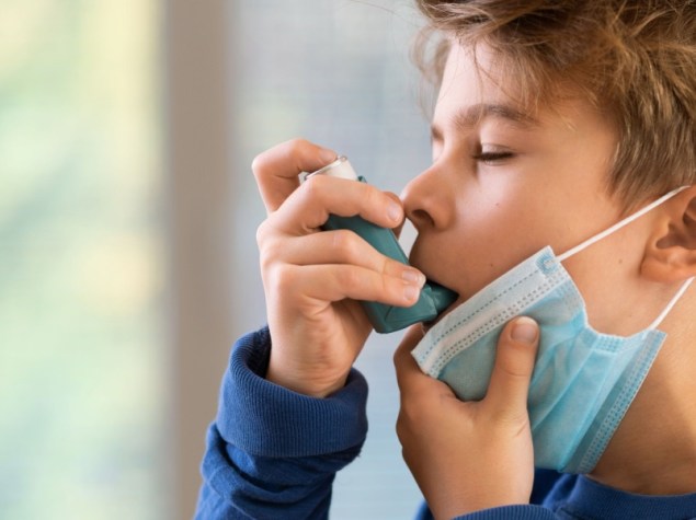 Ragazzo con inalatore di asma a casa