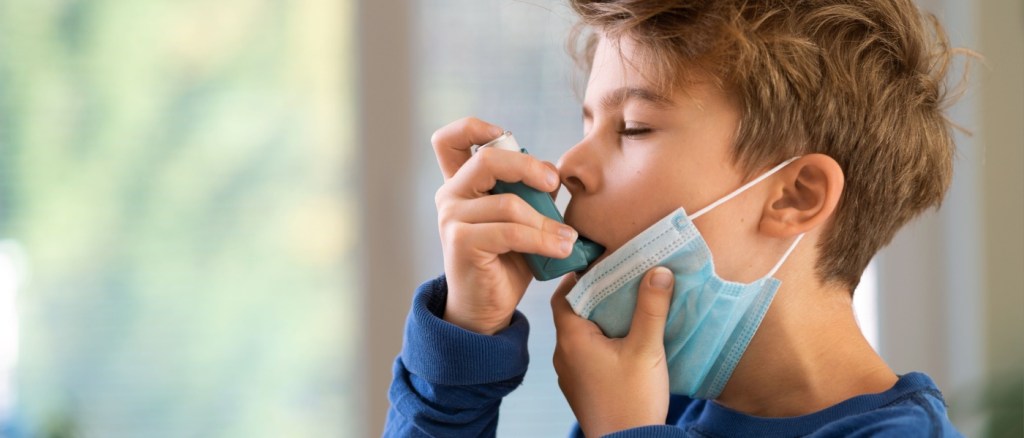 Ragazzo con inalatore di asma a casa