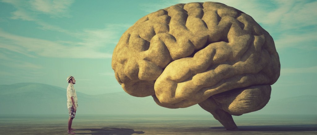 immagine surreale di un uomo con di fronte un cervello grande 2 volte lui