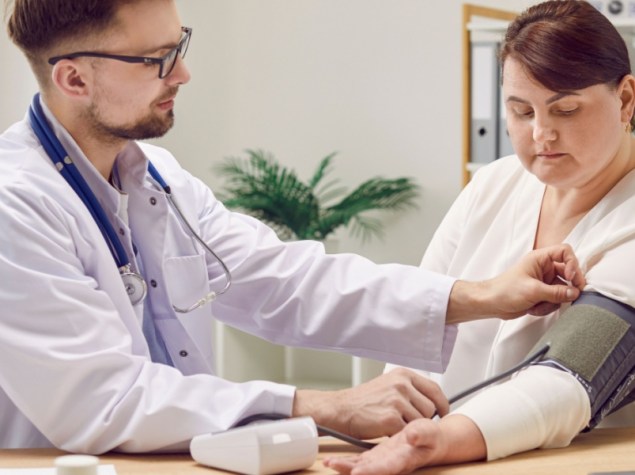 Obesa si misura la pressione con un medico