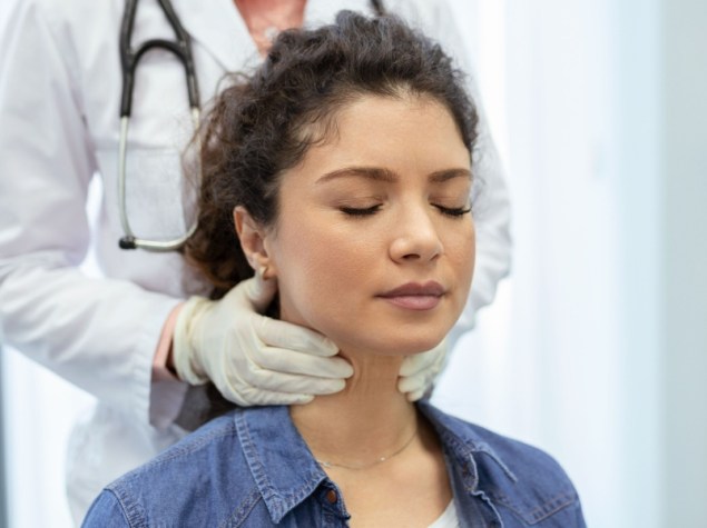 Medico tasta tiroide paziente