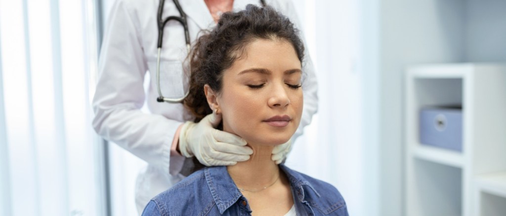 Medico tasta tiroide paziente