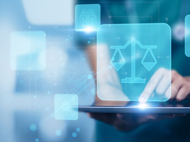 dottoressa che tiene in mano un iPad da cui esce un ologramma a formadi bilancia