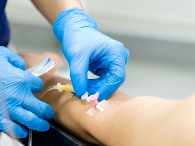 Medico infila catetere endovenoso nel braccio di un paziente