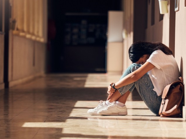 Ragazza seduta a terra in un corridoio