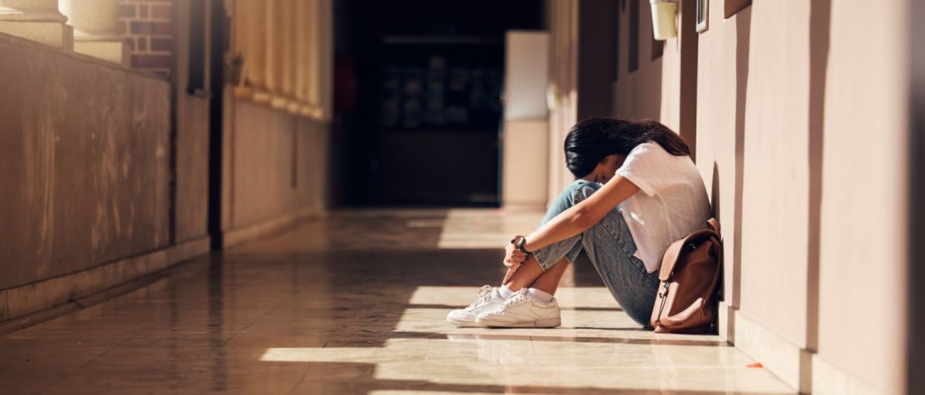 Ragazza seduta a terra in un corridoio