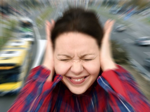 Donna che si copre le orecchie per il forte rumore del traffico