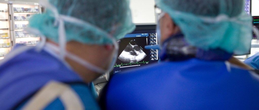 Medici in sala operatoria guardano schermo