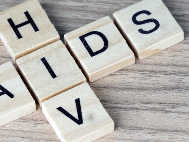 Scritta "AIDS/HIV " composta da tesserine di legno bianco
