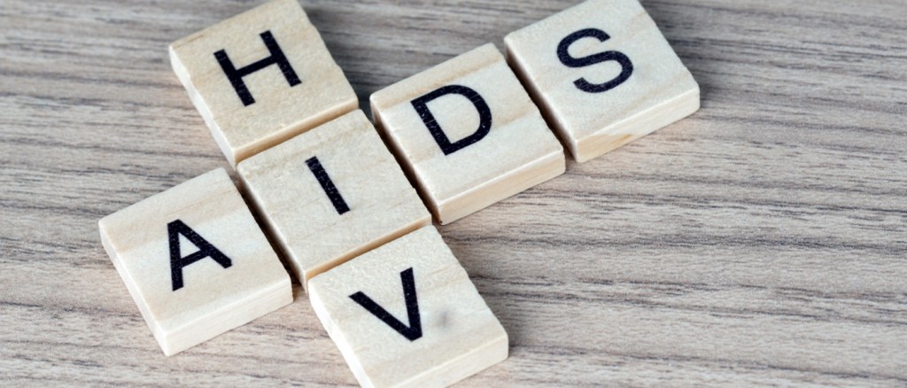 Scritta "AIDS/HIV " composta da tesserine di legno bianco