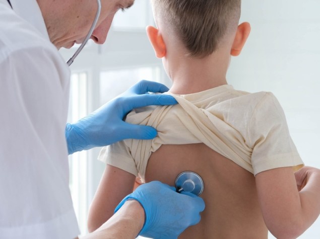 Medico ausculta i polmoni a un bambino