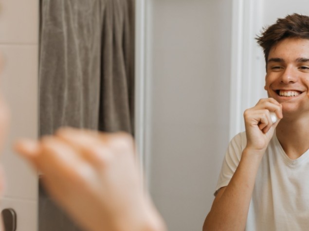 Adolescente si passa il filo interdentale