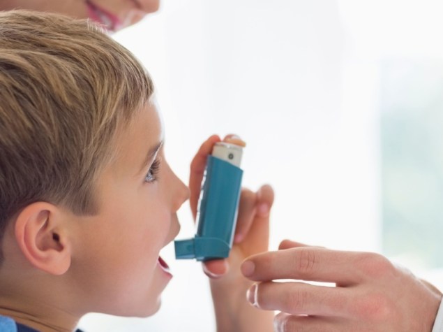Bambino usa inalatore aiutato dai genitori