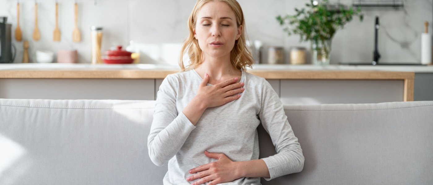 Donna sul divano fa esercizi respiratori