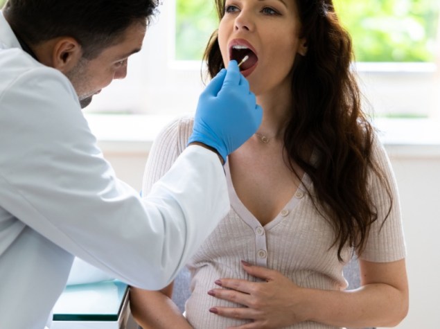 Medico effettua tampone orale a donna incinta