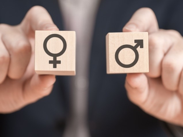 Persona tiene in mano due cubi con le icone di genere femminile e maschile