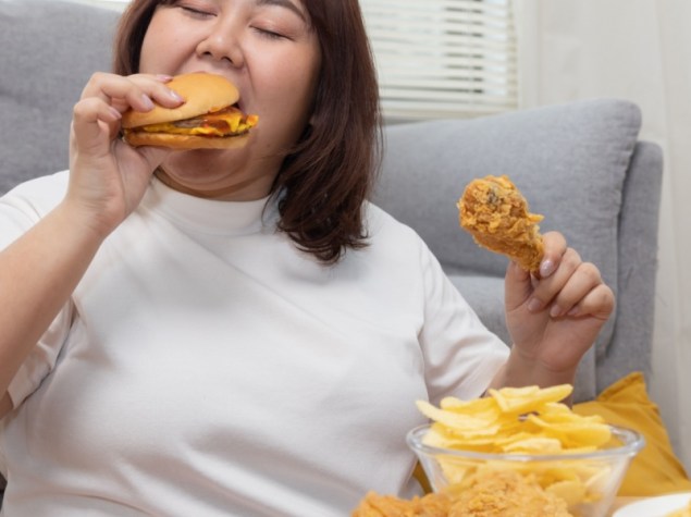 donna che mangia cibo spazzatura