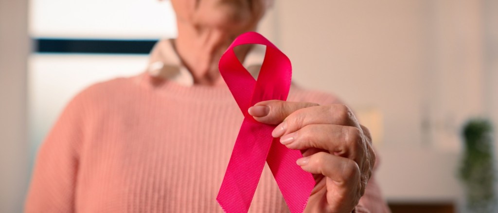 Over 60 che tiene in mano il simbolo dell'hiv