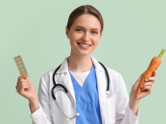 Dottoressa con vitamine e carota