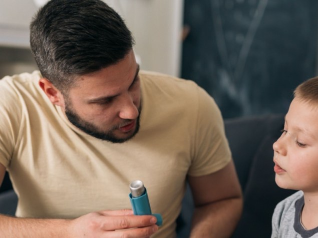padre fa vedere al figlio come si usa inalatore