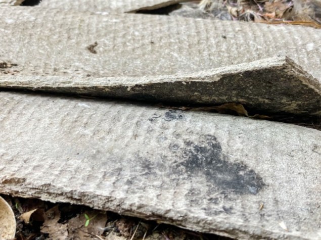 Lastre di cemento-amianto ondulate rotte, vista ravvicinata, cantiere in demolizione