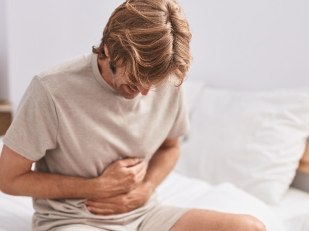 uomo si tocca la pancia per il dolore dell'infenzione