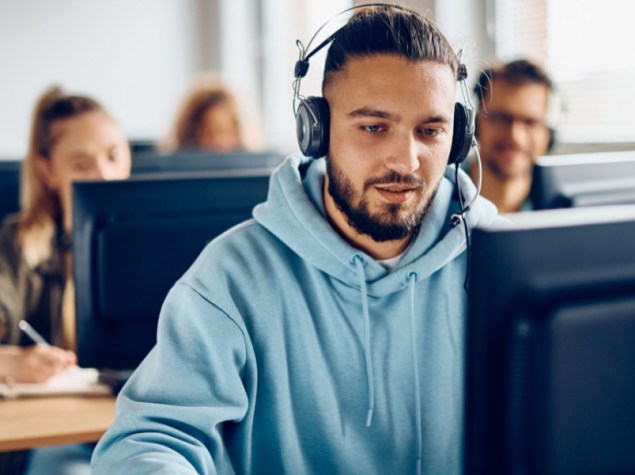 Male student using desktop PC during computer class at the university.
