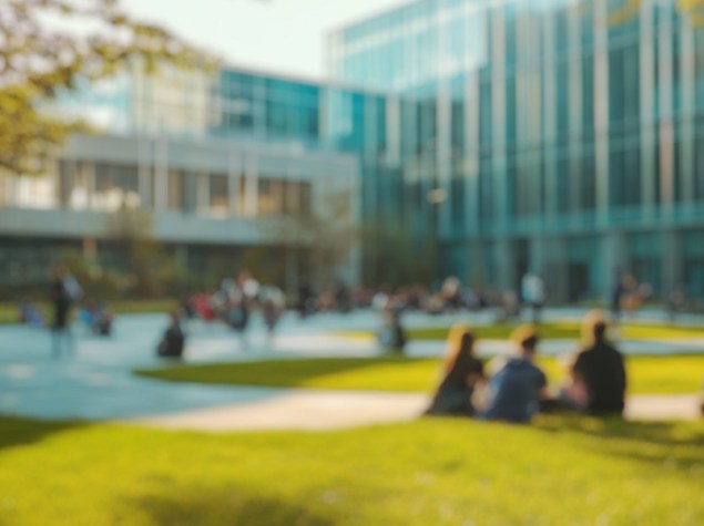 Sfondo sfocato di una scena vivace che mostra studenti che si divertono nel loro tempo libero in un campus universitario contemporaneo