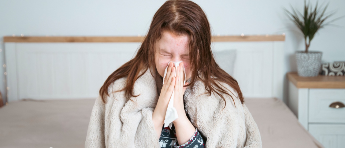 Ragaza con raffreddore si soffia il naso