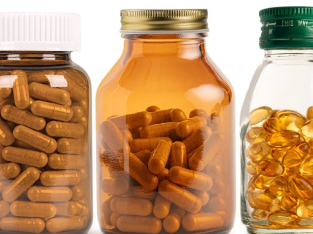 Set di bottiglie di vetro di integratori e vitamine isolate su sfondo bianco