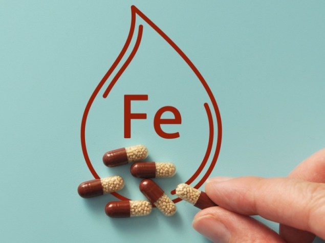 Concetto dell'integratore di ferro con le pillole e l'icona della goccia