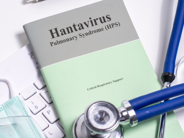 Un foglio di carta con la scritta "Hantavirus" è appoggiato sulla scrivania di un medico, circondato da strumenti medici