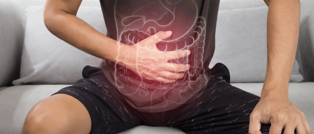 Dolore Gastrointestinale, uomo con mano sullo stomaco