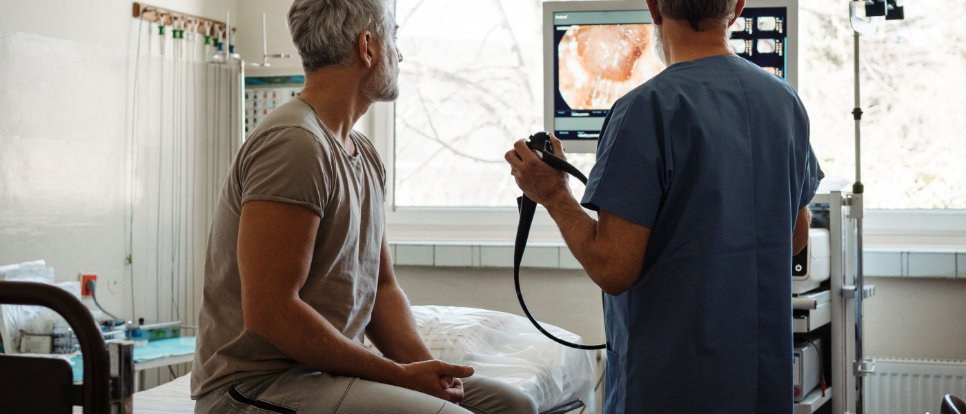 Il medico spiega i risultati della colonscopia al paziente utilizzando le immagini visualizzate sullo schermo