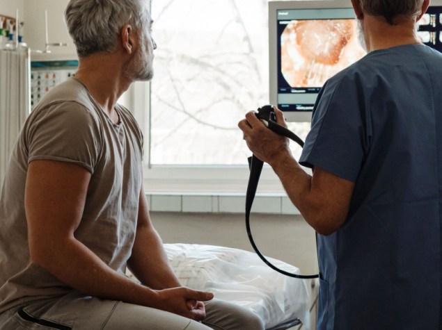 Il medico spiega i risultati della colonscopia al paziente utilizzando le immagini visualizzate sullo schermo