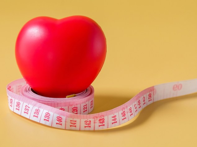 Palla rossa del cuore sul nastro di misura.